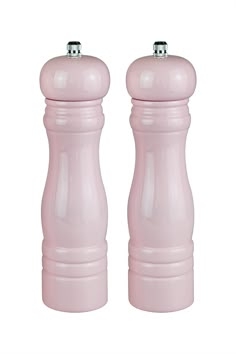 two pink salt and pepper shakers sitting next to each other on a white background