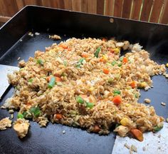 a pan filled with rice and vegetables on top of a table