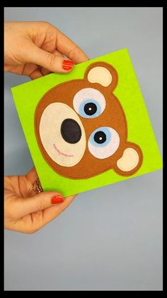 someone is holding up a small card with a bear on it's face and eyes