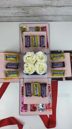 candy bars and roses are arranged on pink trays