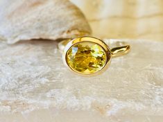 This classic bezel setting contains a beautiful 2.00 ct. genuine lemon citrine. The oval cut stone measures approximately 9x7mm. The ring is available in sterling silver, and 14k white, yellow, or rose gold. This ring makes a great everyday, promise or engagement ring. Please send me a message if you need a size not listed. * This ring can be customized with any color center stone. All items are handmade by me in my shop in Woodbridge, NJ. Please message me with any questions. Shipping within th East West Ring, Prasiolite Ring, Citrine Ring Engagement, Gemstone Solitaire Ring, Blue Aquamarine Ring, November Birthstone Ring, Bezel Engagement Ring, Green Amethyst Ring, Emerald Ring Gold