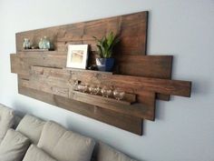 a living room with a couch, table and wall mounted wine rack on the wall