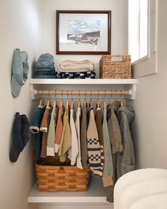 a closet filled with clothes and shoes next to a framed picture on the wall above it