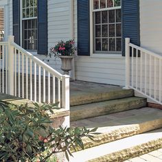 a white porch with blue shutters and flowers