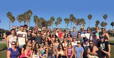 a group of people posing for a photo in front of palm trees