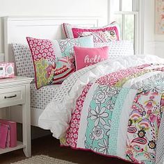 a white bed topped with lots of colorful pillows