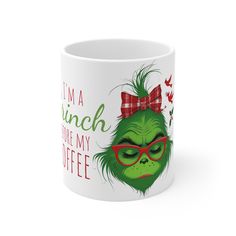 a coffee mug with the grin face wearing glasses and a red bow on its head