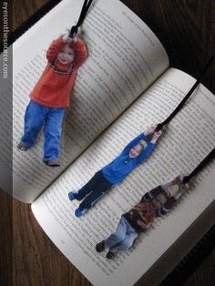 an open book with two children hanging from it