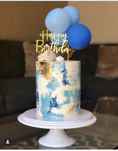 a birthday cake with blue balloons on top