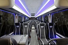 the interior of a modern commuter bus with blue lights and black leather seats on both sides