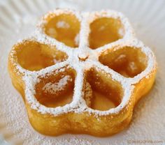 a close up of a pastry on a plate with powdered sugar in the middle