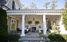 the front porch is decorated with potted plants