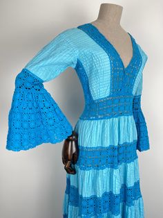 As featured in the Clerkenwell Vintage Fashion Fair, London This beautiful original 1970s Mexican lace dress is a true rarity. In the most breathtaking shade of turquoise, cotton panels are tiered with hand crocheted panelling and elegant angel flared sleeves.  Hours of craftsmanship went into this treasure and she's ready to be enjoyed again, perhaps a turquoise blue sea backdrop of a holiday would be a fitting setting for her. MEASUREMENTS APPROX:  Shoulder, across: Total: Pit to pit/bust, acr Blue Maxi Crochet Dress For Beach, Blue Maxi Crochet Dress For The Beach, Blue Crochet Maxi Dress For Beach, Blue Crochet Maxi Dress For The Beach, Blue Crochet Maxi Dress For Summer, Blue Lace Maxi Dress With Lace Trim, Light Blue Bohemian Dress With Lace Trim, Blue Lace Maxi Dress With Long Sleeves, Fitted Blue Maxi Dress With Lace Trim