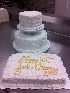 two white wedding cakes sitting on top of a counter next to each other in a kitchen