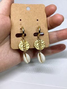 A beautiful handmade pair of gold plated brass disc cowrie shell earrings versatile enough to wear every day, and suit any occasion. Earrings made with cowrie shells and gold plated metal brass disc beads. Lightweight and easy to wear, these dangle earrings are 5 cm long with 24K gold plated hoops. Cowrie Shell Hammered Disc Hoop Earrings made with materials: -24K Gold Plated leverback hoops earring measures 15 mm diameter 1.6cm long -hammered gold spacer disc  beads matte gold plated brass 15 m Gold Jewelry For Summer Beach, Gold Beachy Jewelry For Beach Party, Handmade Hoop Earrings For The Beach, Handmade Hoop Earrings For Summer Vacation, Bohemian Small Hoop Earrings For Beach, Gold Hoop Jewelry For Beach, Gold Drop Earrings For Vacation, Gold Small Hoop Jewelry For The Beach, Gold Jewelry For Summer Vacation