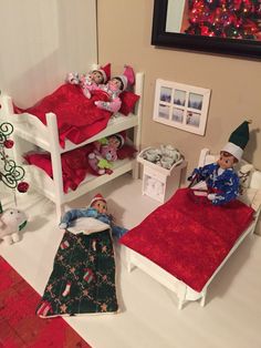 two dolls are laying on their beds in the dollhouse room with christmas decorations around them