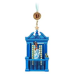 a christmas ornament with a woman in a blue dress hanging from it's side