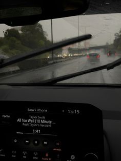 the dashboard of a car on a rainy day with cars driving down the road in the rain