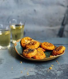 some food is sitting on a plate next to two cups and a glass filled with water