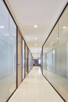 an empty hallway with glass walls and doors