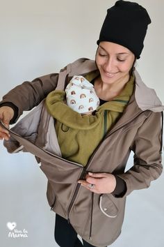 a woman wearing a hat and jacket holding a stuffed animal