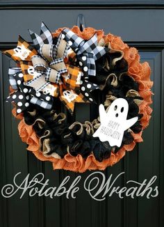 a halloween wreath with black, orange and white decorations