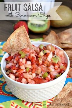 a white bowl filled with salsa next to tortilla chips on a colorful table cloth