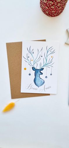 a card with a reindeer head on it next to some scissors and other crafting supplies