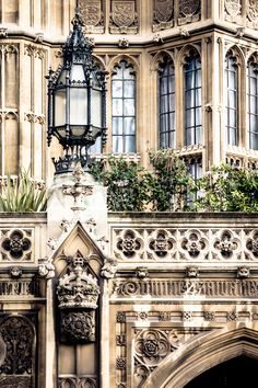 an ornate building with a lamp on top and plants growing out of the window sill