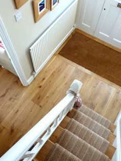 an overhead view of a stair case with pictures on the wall and wooden flooring