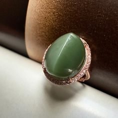 "This beautiful customer made green Hetian  nephrite jade ring is brand new.  The centre stone is one oval shape natural Hetian nephrite jadeite cabochon gemstone, untreated,  in slightly golden light green color.  The stone has been cut to two sides with a soft \"spin\" line, and highly polished to display a luminous band reminiscent of the eye of a cat; this particular quality is termed chatoyancy. Please watch the video clip to see the cat's eye reflection when moving the ring. It measures approximately 16 x 13.5mm in dimension, and 8mm in height. The jade has very high clarity and even color, no visible inclusion that can be seen by eyes or through the high light.  The stone is set on a 925 solid silver band with rose gold finish, as the hallmark shown on the ring. A raw of tiny CZ acc Luxury Handmade Chrysoprase Ring, Eye Reflection, Silver Halo Ring, Columbian Emeralds, Light Green Color, Hetian Jade, Nephrite Jade, Golden Light, Engagement Ring Sizes