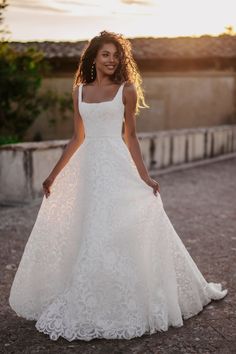 a woman in a white wedding dress standing outside