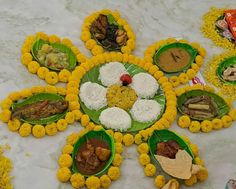 a table topped with lots of different types of food on top of flowers covered plates