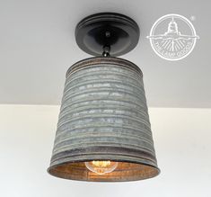 an old tin can light fixture hanging from the ceiling