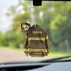 a fireman's jacket hanging from the back of a car with a helmet on it