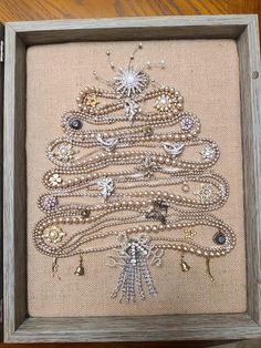 a christmas tree made out of beads in a frame