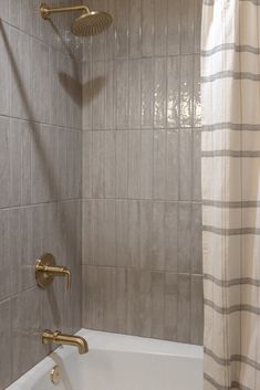 a bathroom with a tub, shower head and hand held faucet in it