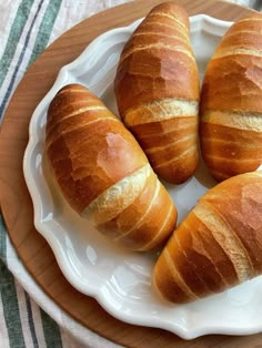 four croissants are on a white plate