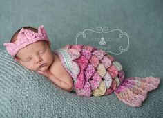 a baby sleeping on top of a blanket covered in crochet