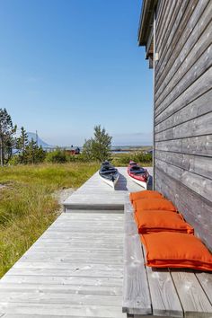 there is a boat sitting on the dock next to the house with an orange pillow