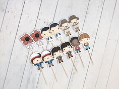 the beatles cake toppers are arranged on toothpicks in front of a white wooden background