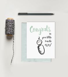 a card with the words congrats on it next to a spool of thread