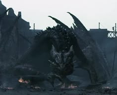 a large dragon standing in the middle of a dirty area with fire coming out of its mouth