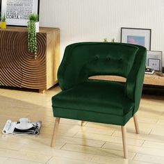 a blue chair sitting on top of a hard wood floor next to a table and dresser