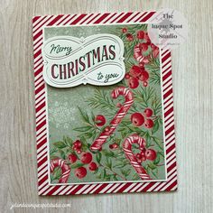 a christmas card with red berries and green leaves, on a wooden background that says merry christmas to you