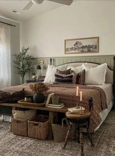 a bedroom with a bed, table and two baskets on the floor next to it