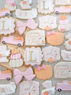 decorated cookies are arranged on a table for a baby's first birthday party with pink and white accents