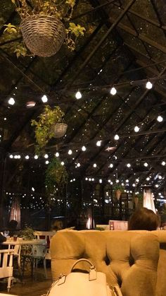 the interior of a restaurant with tables, chairs and chandeliers hanging from the ceiling