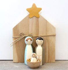 a nativity scene with two wooden dolls and a star