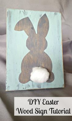 a wooden sign with the word diy easter on it and a cotton ball sitting in front of it